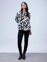 Blusa de gasa satén estampada con diseño animal print en tonos naranja y negro, de la marca Ninety. Tiene mangas tres cuartos y cuello redondo.