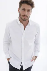 Camisa rosa de manga larga con cuello clásico y cierre frontal con botones. Corte recto.