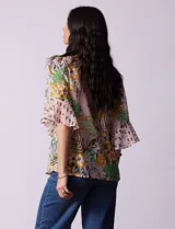 Blusa de gasa estampada con cuello a la base y lazo. Tiene plisado en la delantera, detalles de brillo en lurex, abertura central con botones y mangas 3/4 fluidas.