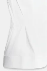 Camisa de cuello solapa y manga sisa, de color blanco. Presenta bajo acabado en peplum y cierre frontal con botones ocultos.