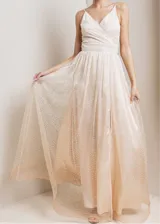 Vestido largo de fiesta con escote en V cruzado y breteles finos. Confeccionado en tela con acabado brillante y falda con caída fluida.