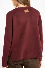 Sweater de tejido de punto color bordó, con cuello redondo, mangas largas y puños acanalados. Presenta un diseño de corte recto y textura suave.