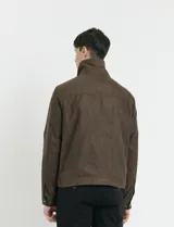 Campera Harrington de gamuza en color marrón, con cierre frontal, cuello clásico y bolsillos laterales con solapa.