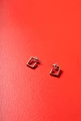 Aros de diseño cuadrado con estructura de metal dorado y bordes rectos, con cierre de presión.