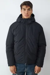 Campera acolchada negra con capucha integrada, cierre frontal de cremallera y bolsillos laterales con cierre.