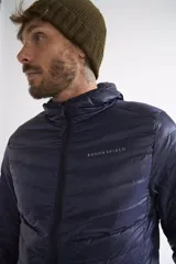 Campera de plumas liviana para hombre, color verde oliva, con capucha, cierre frontal completo y logo de la marca estampado en el pecho.