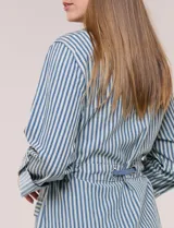 Campera liviana de algodón con estampado de rayas azules y blancas, corte semi holgado con cordón ajustable en la cintura. Cuenta con cuello camisero, cierre frontal con botones, bolsillos con solapa en la parte inferior y mangas largas regulables.