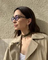 Gargantilla tipo choker de gamuza con dijes colgantes artesanales de metal y perlas naturales. Cuenta con tiras largas para atar y ajustar en la parte posterior.
