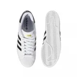 Championes Adidas modelo Superstar ADV, color blanco con las icónicas tres rayas laterales en negro y detalle en el talón. Presenta la clásica puntera de goma y diseño de corte bajo.