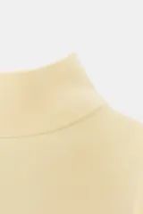 Jersey de punto color amarillo claro, con cuello subido, manga corta con hombreras y cintura entallada.