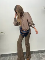 Pantalón acampanado color marrón, de tela alicrada, con diseño clásico.