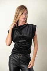 Blusa negra con lunares blancos, de corte holgado y mangas cortas.