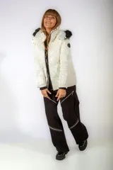 Campera puffer de acabado brillante en color blanco, con capucha desmontable con borde de piel sintética negra, cierre frontal y puños tejidos en color negro.