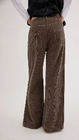 Pantalón de pana de algodón con tiro medio y corte de pierna ancha. Presenta bolsillos traseros con detalles de pespuntes y cierre clásico.