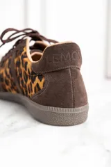 Zapatillas bajas de cuero color marrón con estampado animal print de leopardo, cordones marrones y suela plana.