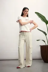 Pantalón cargo color beige de corte ancho, con bolsillos laterales y cordón ajustable en la cintura.