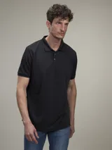 Chomba de piqué negra, de corte clásico, con cuello polo y tapeta de dos botones.