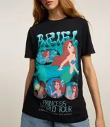 Remera de algodón negro, modelo t-shirt con cuello redondo y manga corta. Cuenta con una estampa frontal colorida de la princesa Ariel de Disney y la inscripción 'Princess World Tour'.