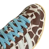 Championes Adidas modelo Japan con exterior de pelo sintético con estampado animal print tipo vaca en tonos marrón y blanco, tres tiras laterales y refuerzo en el talón de cuero blanco, cordones celestes y suela de goma color tostado.