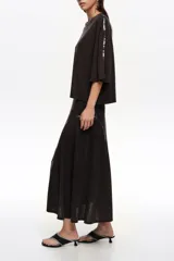 Falda midi de corte línea A, color negro, decorada con líneas verticales de lentejuelas brillantes.