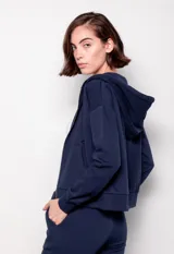 Canguro negro con cierre metálico, cordones y capucha. Tiene bolsillos en el frente.