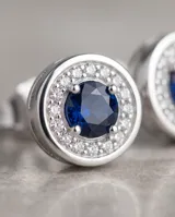 Aros abridores de plata en forma circular, con una piedra central azul rodeada de pequeñas circonias brillantes.