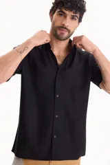 Camisa de manga corta negra, de corte clásico y cuello camisero.