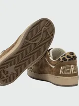 Zapatillas Golden Goose modelo Ball Star, confeccionadas en gamuza marrón con detalles en estampado animal print de leopardo en la puntera y el talón. Presentan una estrella lateral blanca, cordones marrones y suela de goma con efecto desgastado.