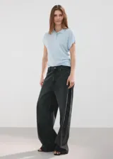 Chaleco de tejido de punto fino color celeste con sutiles lentejuelas, cuello polo y cierre delantero parcial con botones.