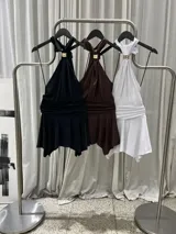 Mini vestido corto color negro de microfibra, con escote halter drapeado, choker incorporado con detalle dorado, espalda descubierta, faja fruncida en la cintura y falda con volado.