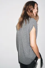 Chaleco oversize de lana color gris, con cuello redondo, manga sisa y bajo asimétrico con aberturas laterales.