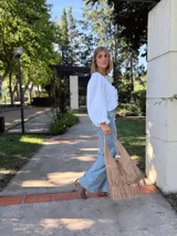 Cartera tipo hobo de cuero color beige con flecos en dos niveles.