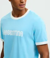 Remera de algodón color celeste con cuello redondo y bordes de mangas en color blanco. Presenta la palabra 'ARGENTINA' estampada en el pecho con tipografía blanca.