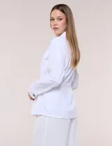 Sobrecamisa beige de lino liviano, con cuello camisero, cierre frontal de botones carey y bolsillos en el pecho. Cuenta con cordón ajustable en la cintura y mangas largas.