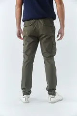 Pantalón cargo de hombre con fit slim, confeccionado en una mezcla de algodón y elastano. Presenta cierre de cremallera y botón, bolsillos laterales tipo cargo, pasa cinto y terminación con puños elásticos en los tobillos.