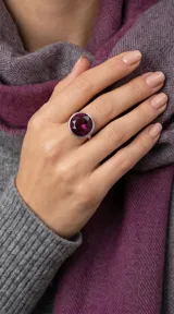 Anillo de plata con cristal redondo facetado en color amatista, engarzado en un diseño minimalista.