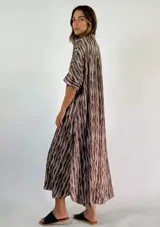 Vestido largo de viscosa con estampado de rayas verticales en tonos marrones y beige, con cuello en V y mangas cortas.