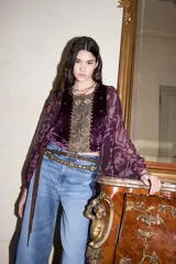 Saco de estilo bohemio confeccionado en terciopelo color violeta, con mangas largas abullonadas de tela fluida estampada. Presenta un panel central bordado con detalles ornamentales y cierre frontal.