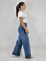 Pantalón de jean azul de tiro alto, corte wide leg y ruedo desflecado.