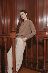 Sweater de punto color taupe, con cuello polo y cierre frontal parcial de botones, de manga larga y calce holgado.