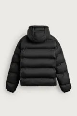 Cazadora puffer acolchada de corte relaxed fit color negro, confeccionada en tejido técnico repelente al agua. Cuenta con cuello subido, capucha ajustable con elásticos y cierre frontal con cremallera. Tiene bolsillos de vivo en la cadera, bolsillo interior y mangas largas con puños elásticos ajustables con abertura para el dedo pulgar.