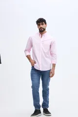 Camisa de manga larga color rosado, con cuello abotonado, cierre frontal de botones y un bolsillo ojal en el pecho.