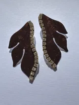 Par de aros colgantes con forma de media flor color marrón con glitter y detalle de strass en el borde.