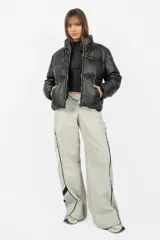 Pantalón deportivo gris de calce recto y tiro medio, con cintura elástica y cordones. Presenta recortes con vivos a contratono en los laterales y una estampa en el lateral izquierdo.