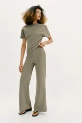 Pantalón largo negro de tiro alto, confeccionado en tejido elástico, con cintura elástica y diseño de pierna ancha tipo palazzo con bajo evasé.