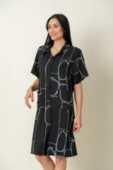 Camisa larga negra con estampado de líneas geométricas en gris, de manga corta y dos bolsillos delanteros.