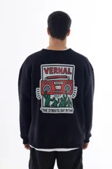 Buzo negro de corte holgado con estampa en la espalda de una radio roja con personas bailando y la frase "The streets got rythm".