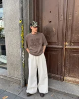 Remera oversize color beige con efecto acid wash y estampa frontal en marrón con la frase "Killing In The Name Of".