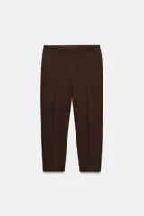 Pantalón de vestir color marrón oscuro, tiro alto, corte recto o ligeramente cropped, con pinzas frontales y bolsillos laterales.