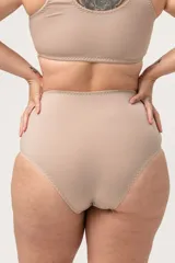 Bombacha tiro alto color piel, con refuerzo en la zona abdominal y confeccionada con tela de fibra LYCRA® reforzada.